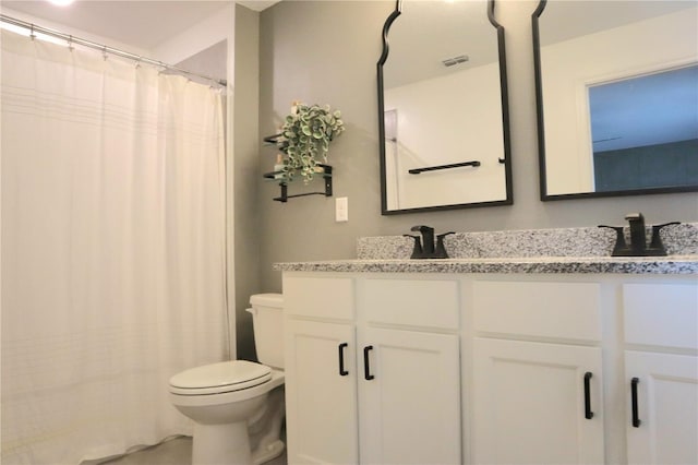 bathroom with curtained shower, vanity, and toilet