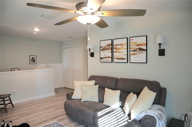 living room featuring light wood-type flooring and ceiling fan