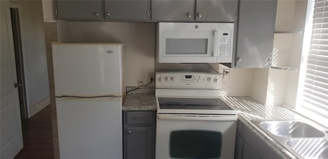 kitchen with gray cabinetry, sink, and white appliances