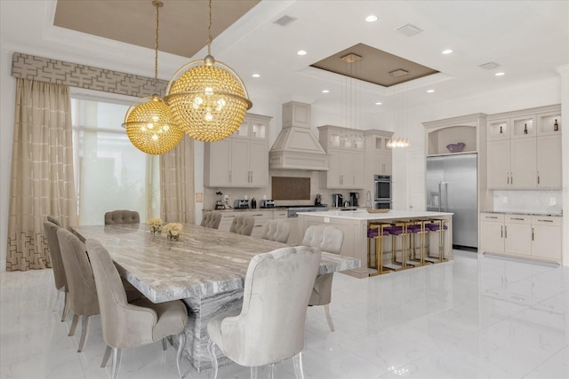 dining room with a raised ceiling, ornamental molding, and a chandelier