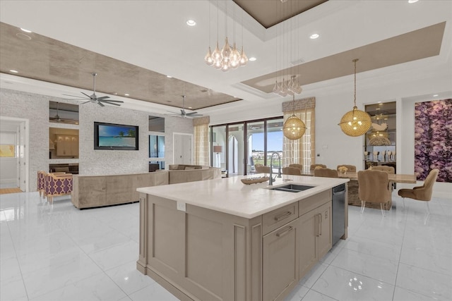 kitchen with decorative light fixtures, a center island with sink, ceiling fan with notable chandelier, and sink