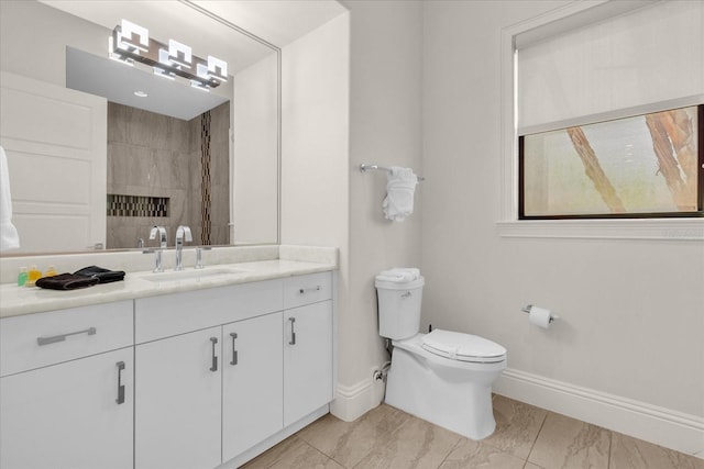 bathroom featuring vanity, toilet, and tiled shower