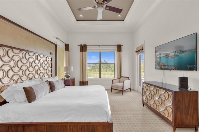 carpeted bedroom with ceiling fan, a raised ceiling, and crown molding