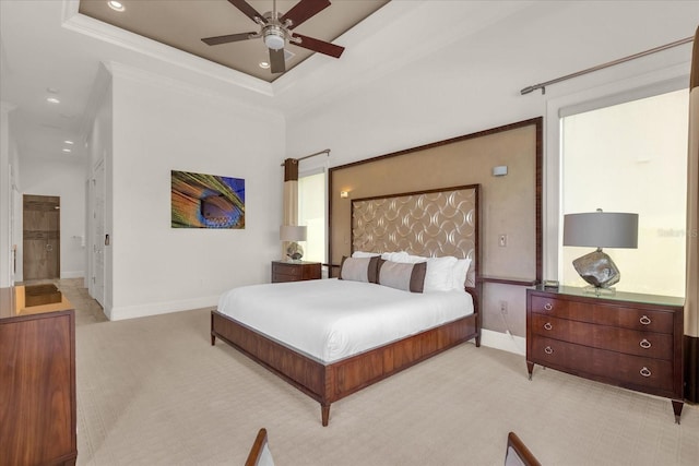 bedroom with light carpet, a tray ceiling, ceiling fan, and ornamental molding