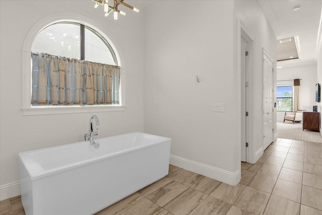 bathroom with a tub to relax in, tile patterned floors, and crown molding