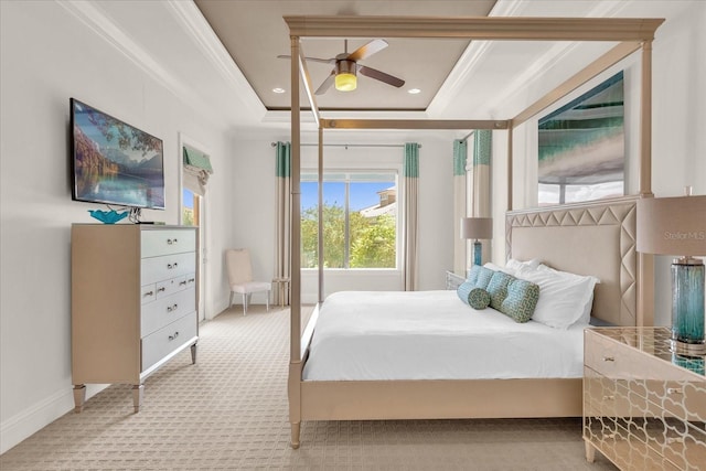 carpeted bedroom with ornamental molding, ceiling fan, and a raised ceiling