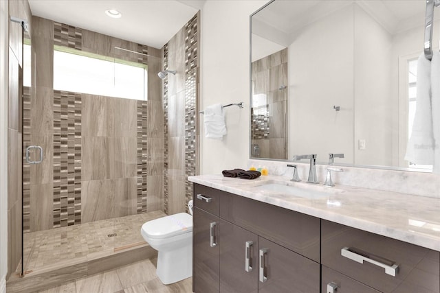 bathroom featuring vanity, tile patterned flooring, ornamental molding, toilet, and a shower with door