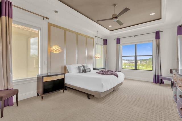 carpeted bedroom featuring a tray ceiling and ceiling fan