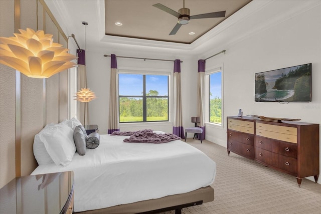 bedroom with a raised ceiling, ornamental molding, light carpet, and ceiling fan