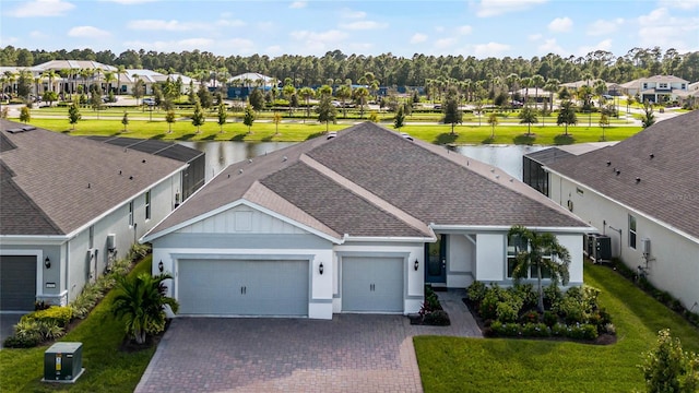 view of front of property with a water view, a front lawn, and a garage