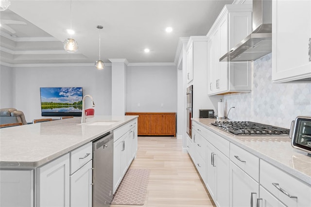 kitchen featuring pendant lighting, a kitchen island with sink, wall chimney range hood, white cabinetry, and stainless steel appliances