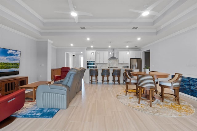 dining space featuring crown molding, a tray ceiling, and ceiling fan