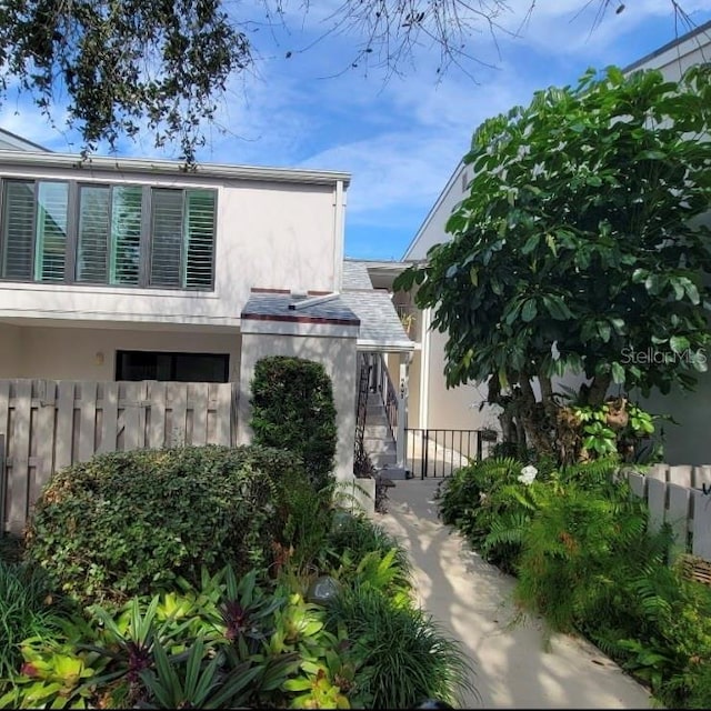 view of side of property with fence and stucco siding