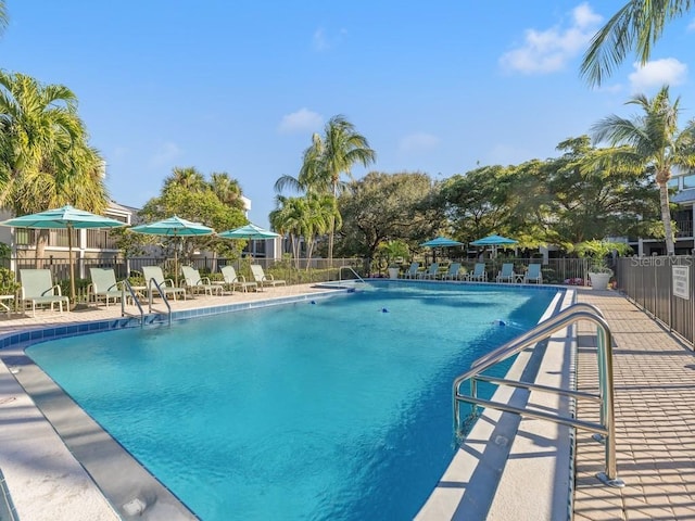 community pool featuring a patio and fence