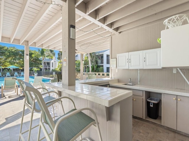 view of patio / terrace with outdoor wet bar and a community pool