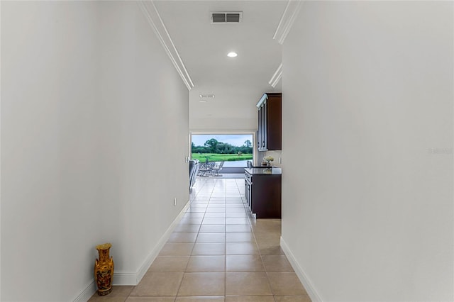 hall featuring ornamental molding and light tile patterned floors