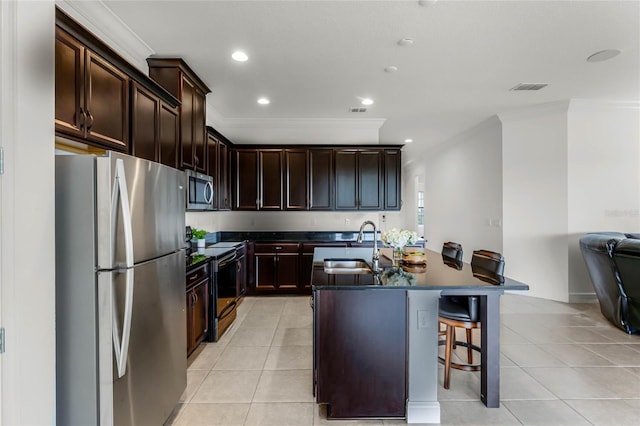 kitchen featuring sink, an island with sink, appliances with stainless steel finishes, light tile patterned floors, and crown molding