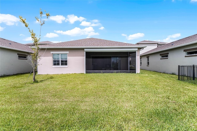 back of property with a sunroom and a yard