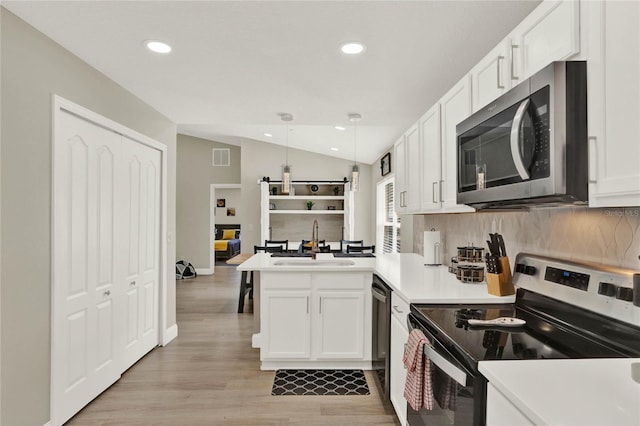 188 Ridgemont Ct, Davenport, FL 33896 - kitchen with stainless steel appliances, lofted ceiling, a peninsula, decorative backsplash, and recessed lighting