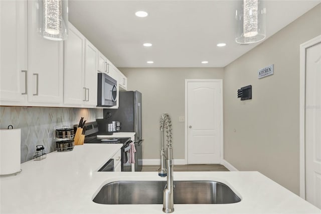 kitchen with white cabinets, appliances with stainless steel finishes, backsplash, and sink