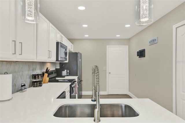 188 Ridgemont Ct, Davenport, FL 33896 - kitchen with stainless steel appliances, recessed lighting, light countertops, white cabinets, and decorative backsplash