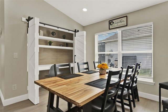 188 Ridgemont Ct, Davenport, FL 33896 - dining room with a barn door, wood finished floors, healthy amount of natural light, recessed lighting, and lofted ceiling