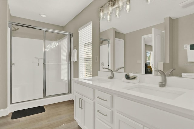 bathroom featuring toilet, vanity, hardwood / wood-style floors, and a shower with shower door