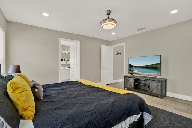 bedroom with wood-type flooring and ensuite bath