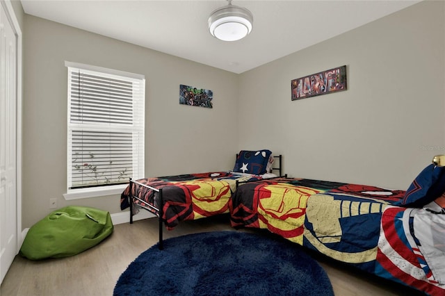 bedroom with multiple windows and hardwood / wood-style floors