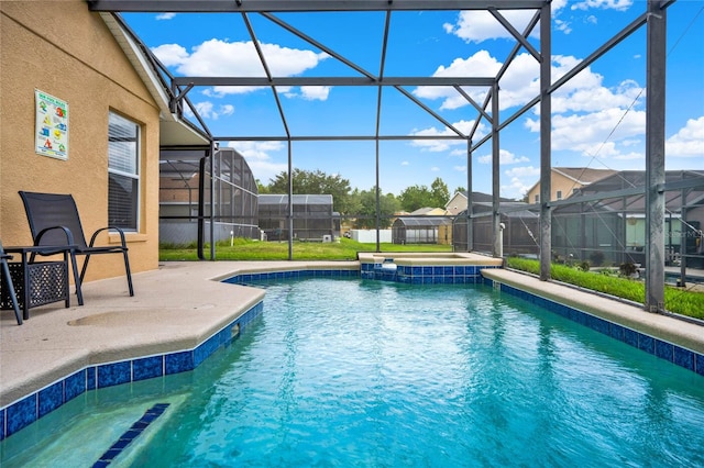 view of pool with glass enclosure and a patio