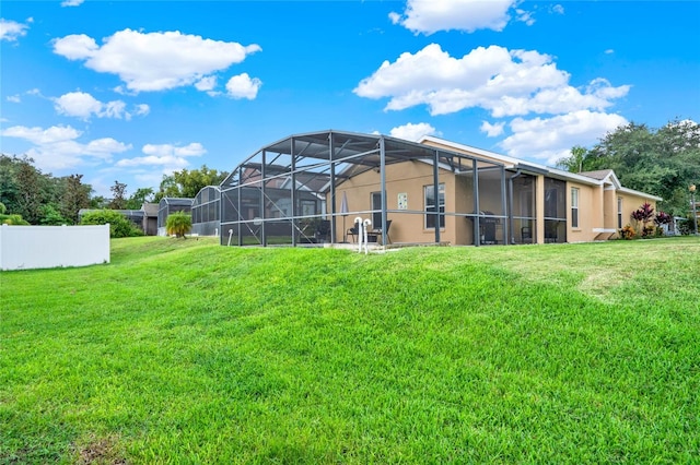 back of property featuring a lawn and a lanai