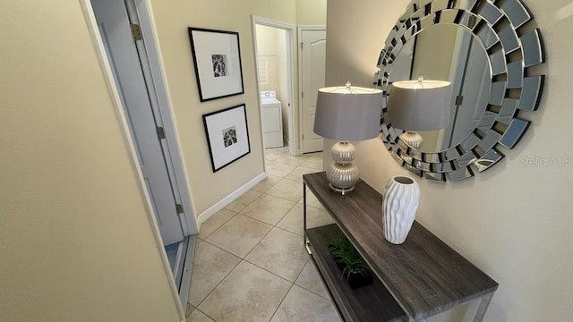 corridor with light tile patterned floors and washer / dryer