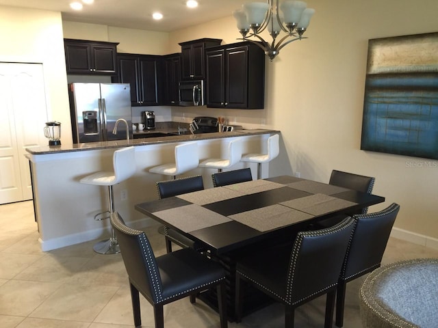 dining space with an inviting chandelier, light tile patterned floors, and sink