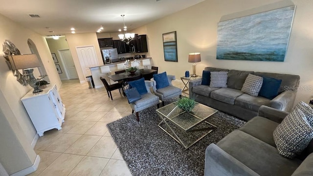 tiled living room with a notable chandelier