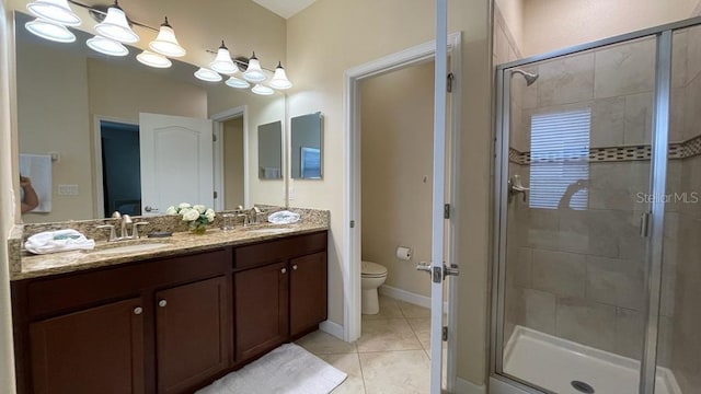 bathroom with vanity, tile patterned flooring, toilet, and a shower with door