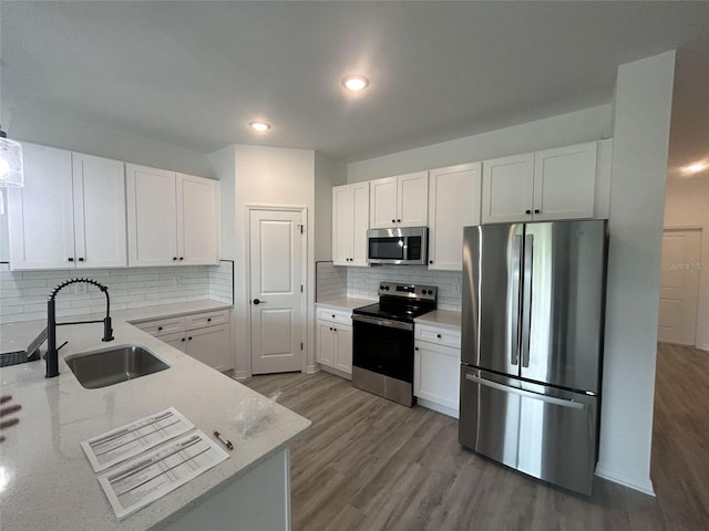 1320 Rio De Janeiro Ave, Punta Gorda, FL 33983 - kitchen with appliances with stainless steel finishes, white cabinetry, backsplash, wood finished floors, and recessed lighting
