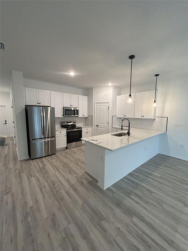 1320 Rio De Janeiro Ave, Punta Gorda, FL 33983 - kitchen with appliances with stainless steel finishes, backsplash, white cabinets, a peninsula, and wood finished floors