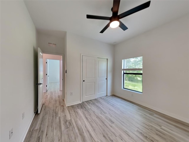 unfurnished bedroom with a closet, light wood-type flooring, and ceiling fan