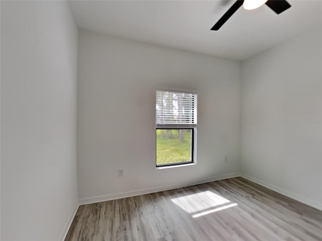 empty room with ceiling fan and light hardwood / wood-style flooring