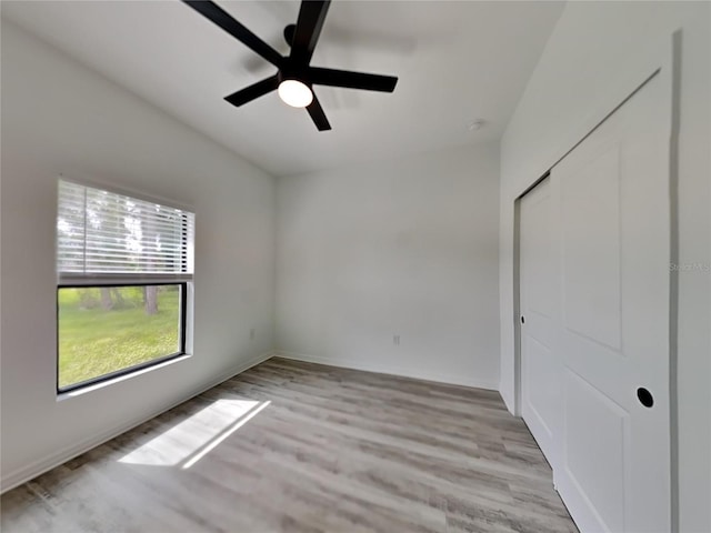 unfurnished bedroom featuring a closet, light wood-type flooring, and ceiling fan