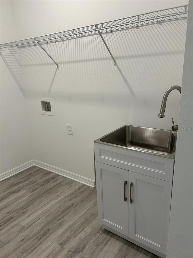 laundry room featuring sink, hardwood / wood-style flooring, and hookup for a washing machine