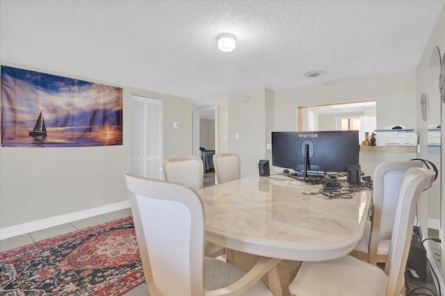 tiled dining room with a textured ceiling