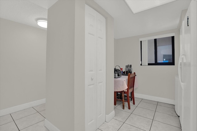 hallway with light tile patterned flooring and a textured ceiling