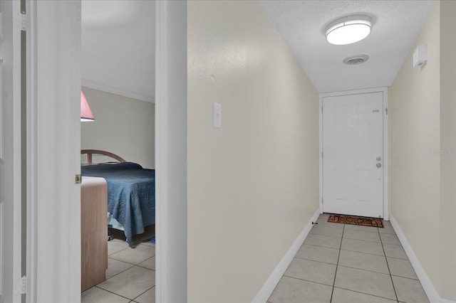 hall featuring a textured ceiling and light tile patterned floors