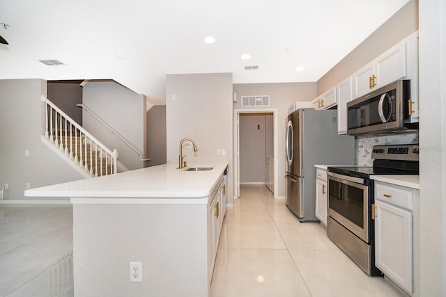 kitchen with white cabinetry, tasteful backsplash, light tile patterned floors, stainless steel appliances, and sink