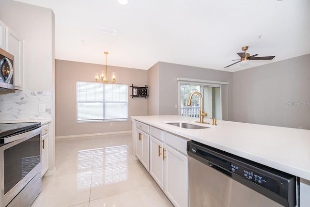 kitchen with sink, tasteful backsplash, white cabinetry, appliances with stainless steel finishes, and ceiling fan with notable chandelier