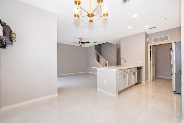 kitchen with appliances with stainless steel finishes, light tile patterned flooring, sink, and ceiling fan