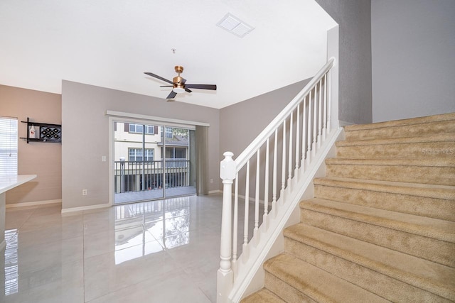 stairs featuring tile patterned flooring and ceiling fan