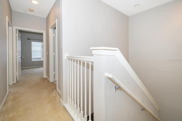 hallway featuring light colored carpet