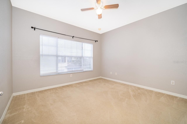 spare room featuring light carpet, lofted ceiling, and ceiling fan